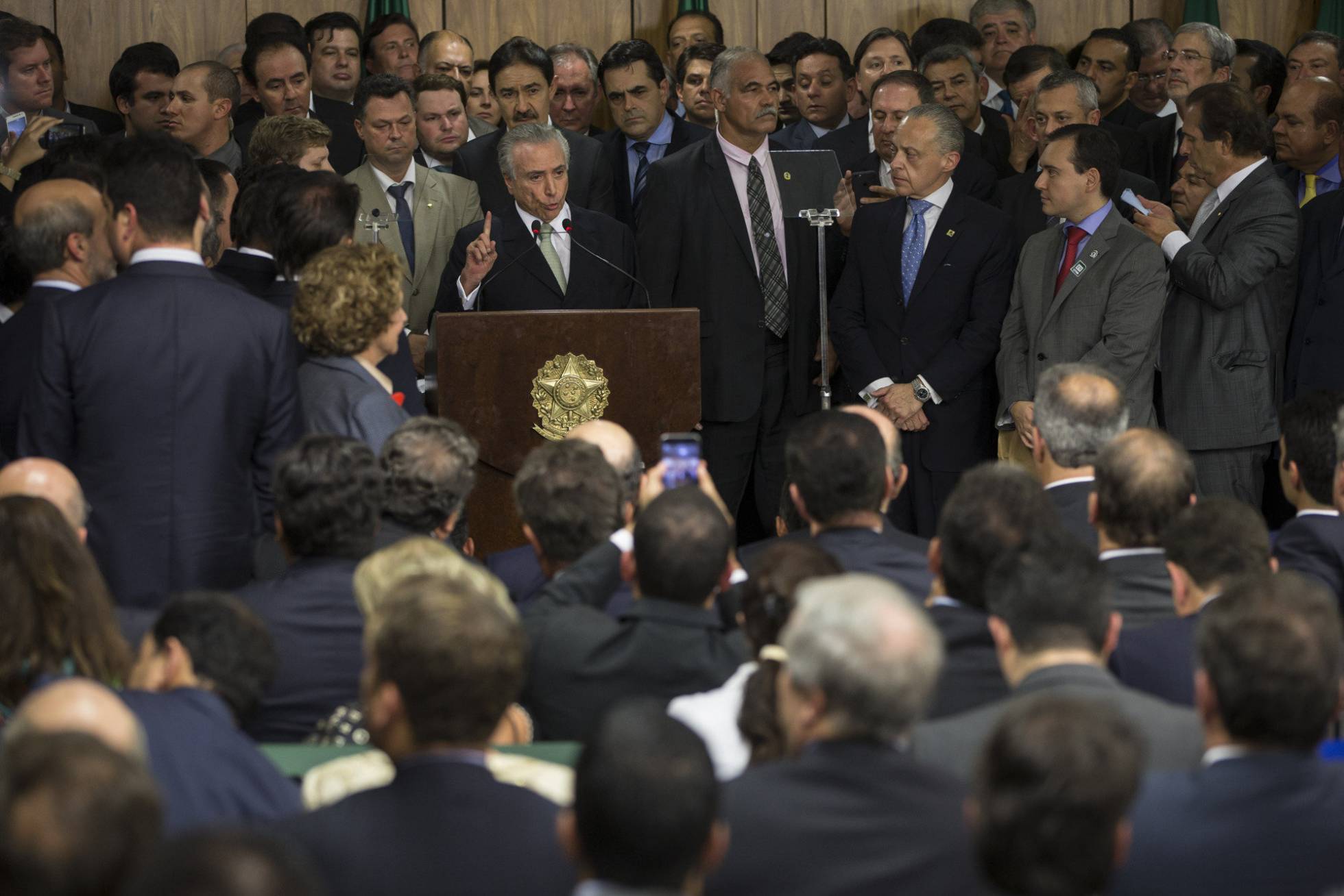 Michel Temer, rodeado de ministros e políticos, ao tomar posse como presidente interino no dia 12 de maio, em Brasília. FELIPE DANA/AP PHOTO (Reprodução do El País)
