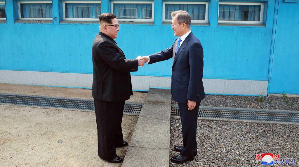 El líder de Corea del Norte, Kim Jong-un, saluda al presidente de Corea del Sur, Moon Jae-in, en la frontera entre las dos coreas este domingo. STR (AFP/Reprodução El País)