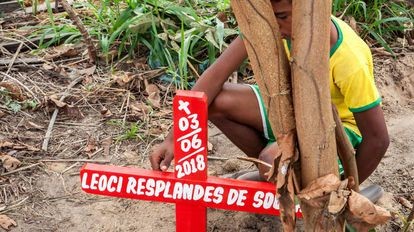 Un niño, junto a la tumba de su padre, asesinado en el Estado de Pará (Brasil) en 2018 por un conflicto de tierras/LILO CLARETO (Reprodução do El País)
