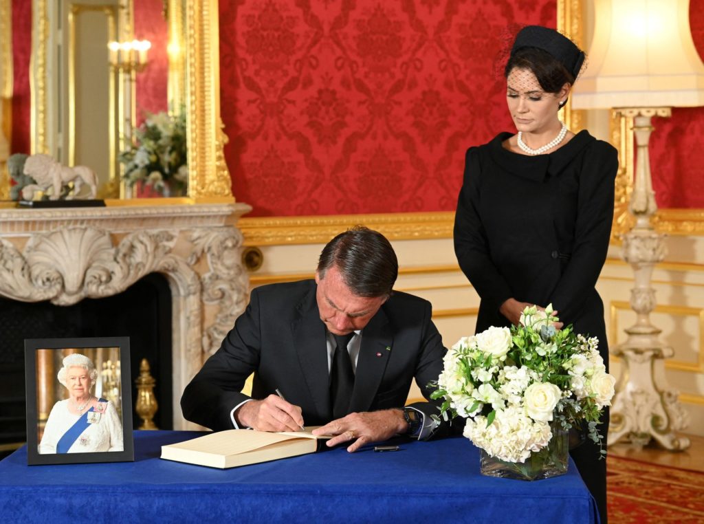 Jair Bolsonaro firmaba el domingo en el libro de condolencias de Isabel II, en Londres. Junto a él, su esposa, Michelle. POOL (REUTERS/ Reprodução do El País)